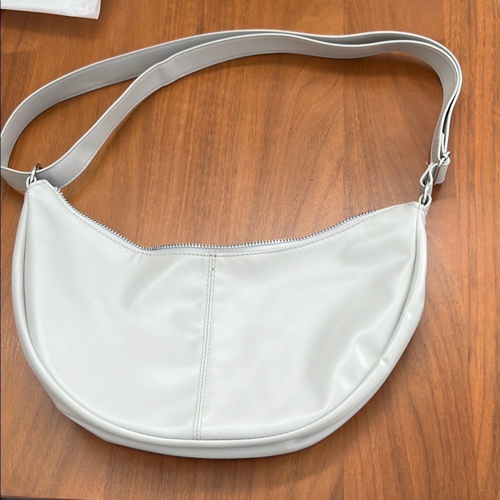 White Crescent Shoulder Bag with Adjustable Strap and Zippered Closure